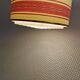 Hanging lamp with brass-coloured details, made of fabric with intact plastic bottom grille.