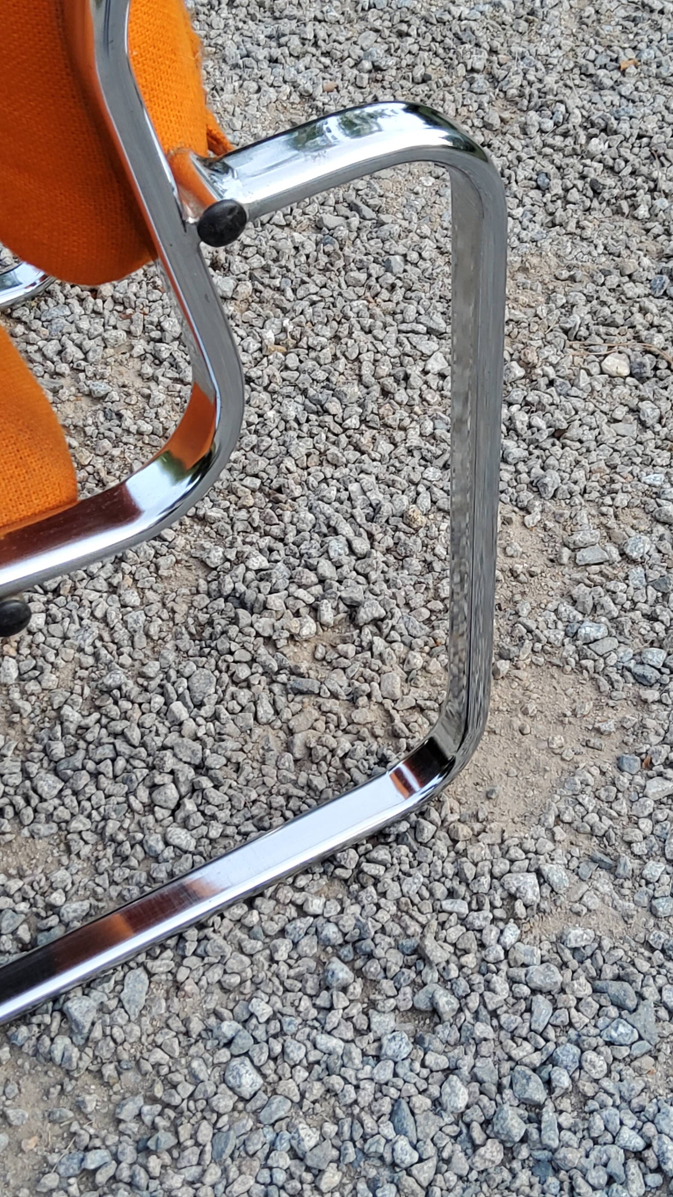 Pair of designer armchairs in orange fabrics and chrome tubes from the 70s