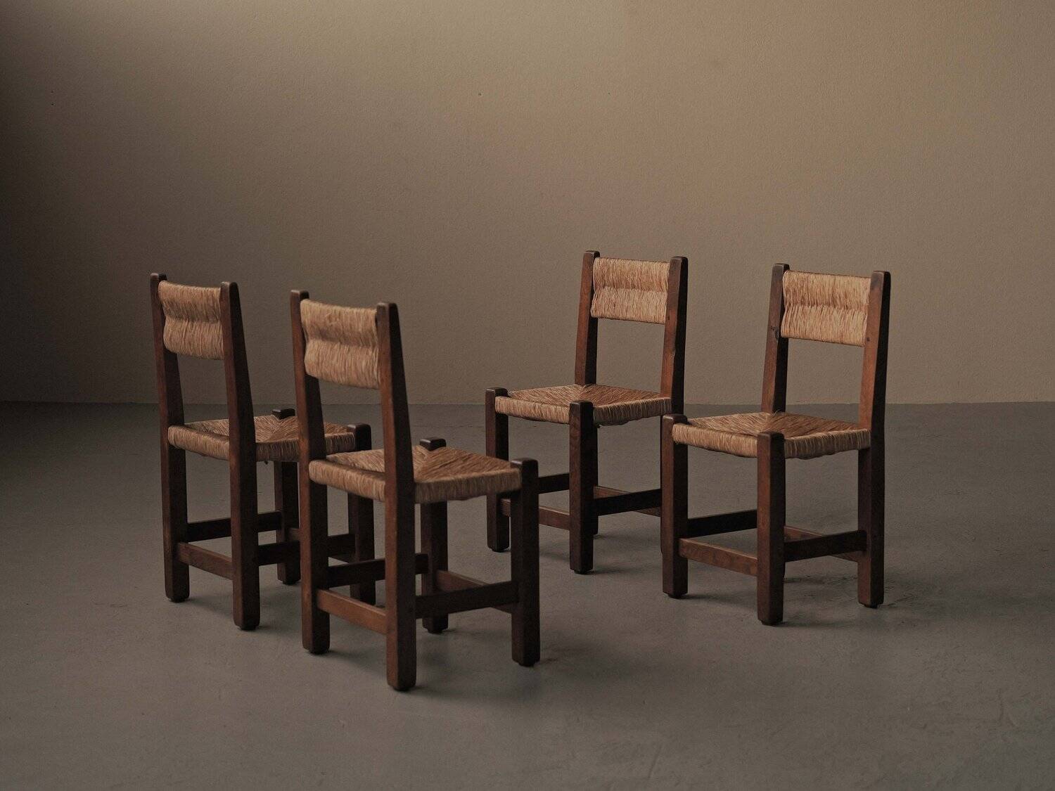 Set of four modernist chairs in oak and straw, France, circa 1960.