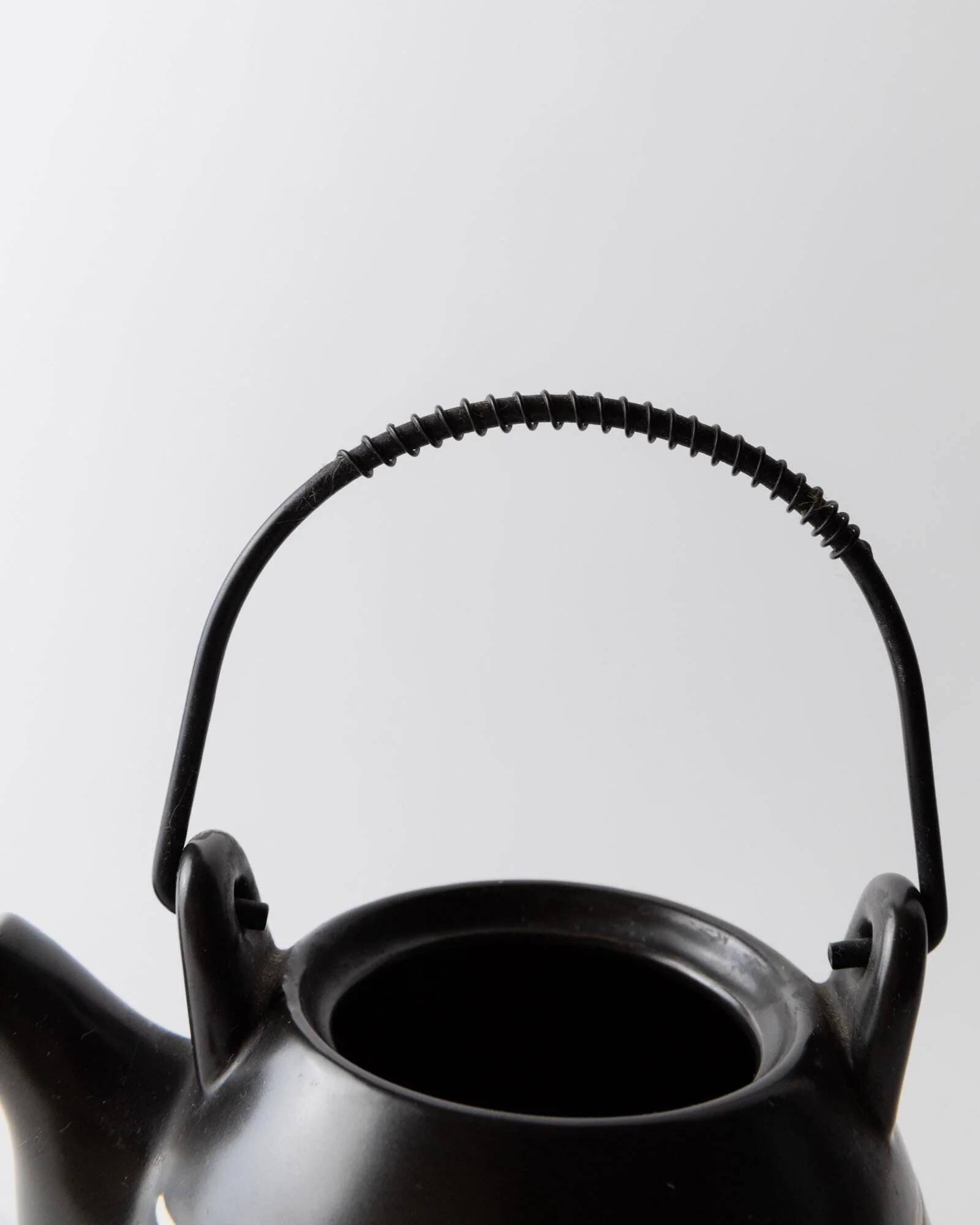 Vintage ceramic teapot from the 1980s, black with white stripes and a metal handle.