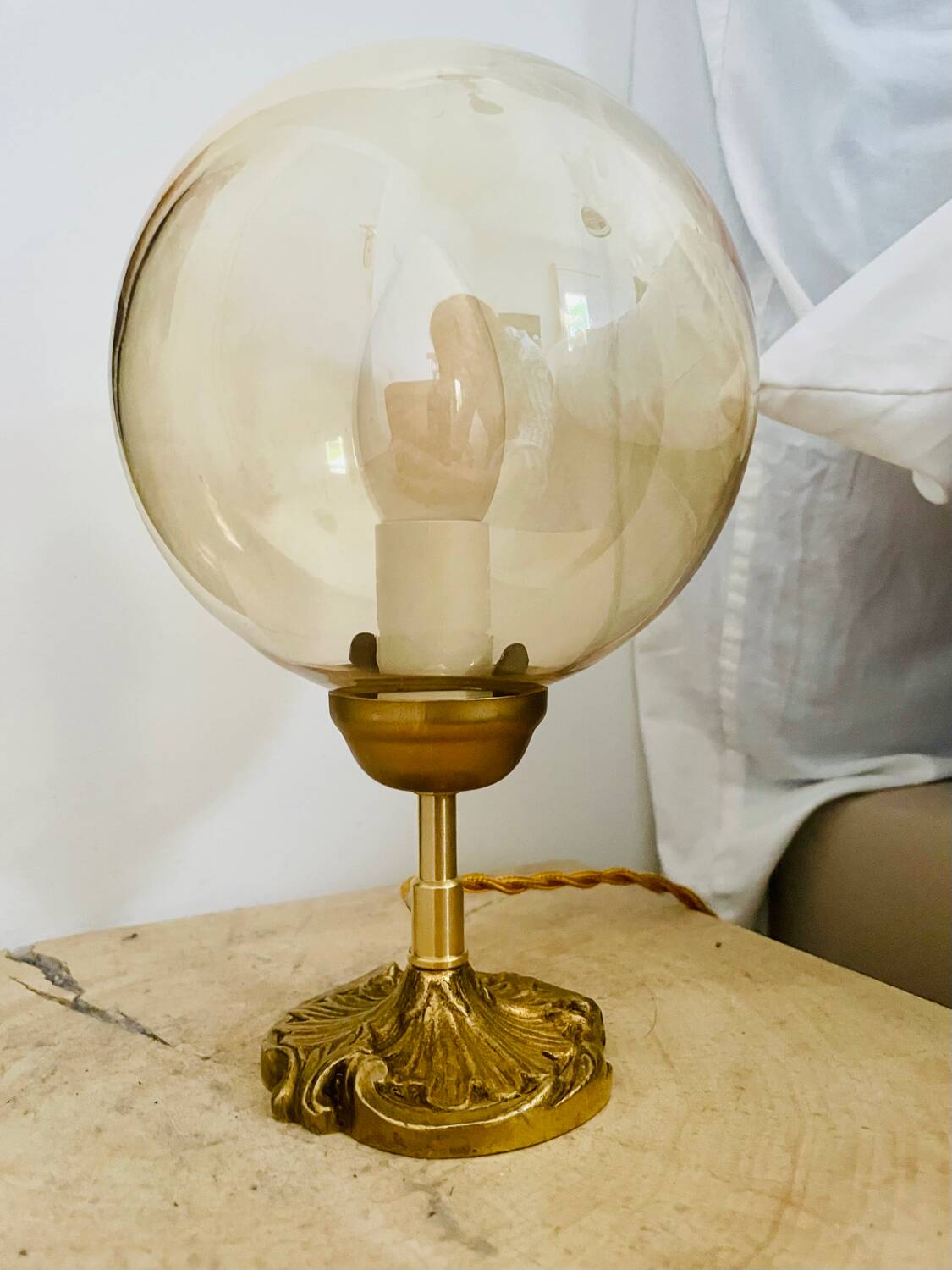 2 bedside lamps with round amber glass globes and gold metal.