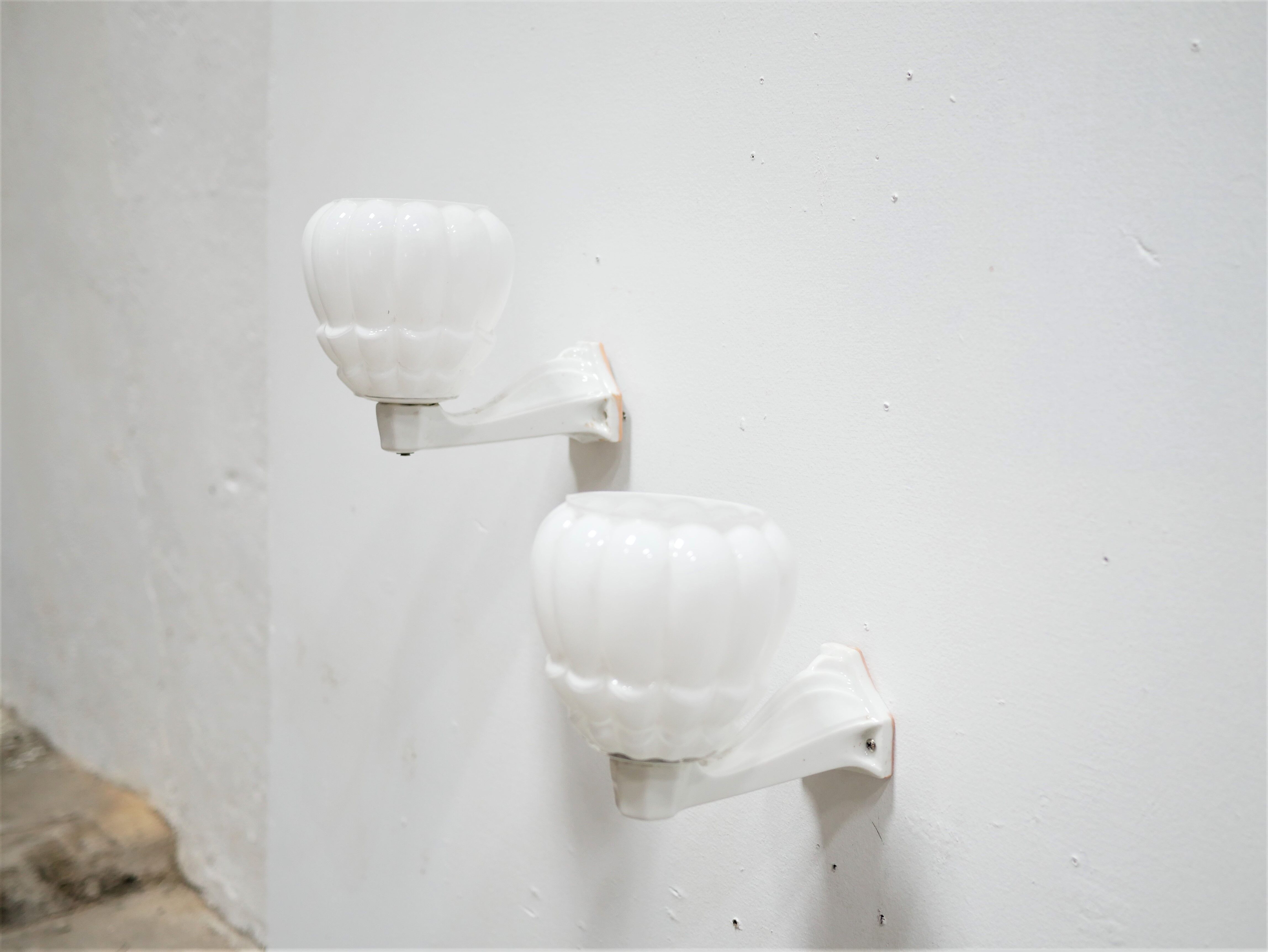 Pair of art deco porcelain and glass wall appliques