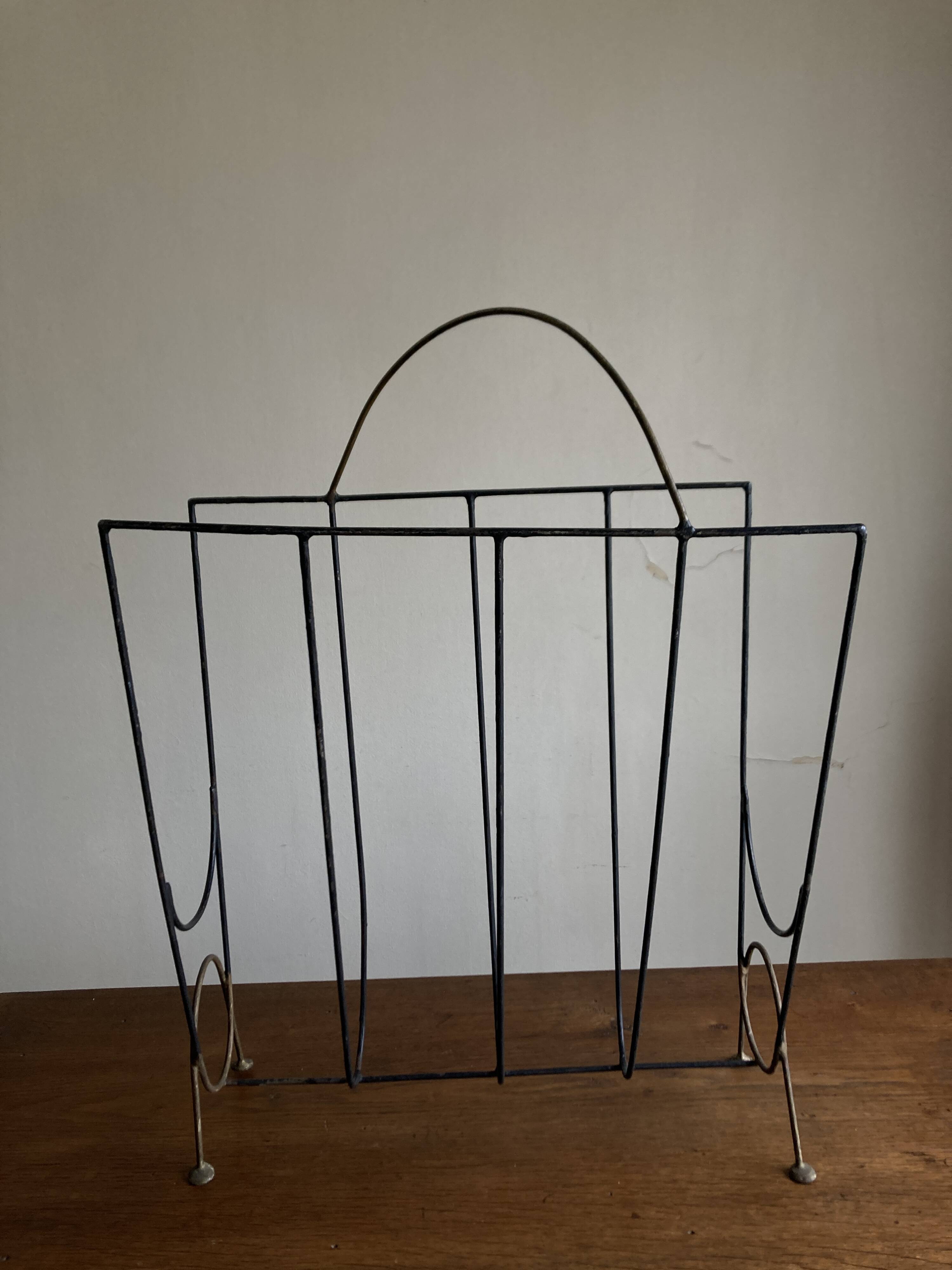Mid-century poetic magazine rack in black metal