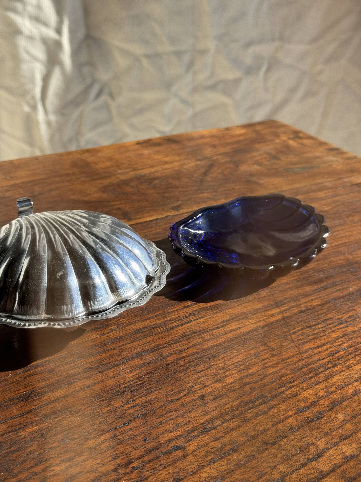 Vintage silver-plated shell butter dish with blue bowl.