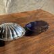 Vintage silver-plated shell butter dish with blue bowl.
