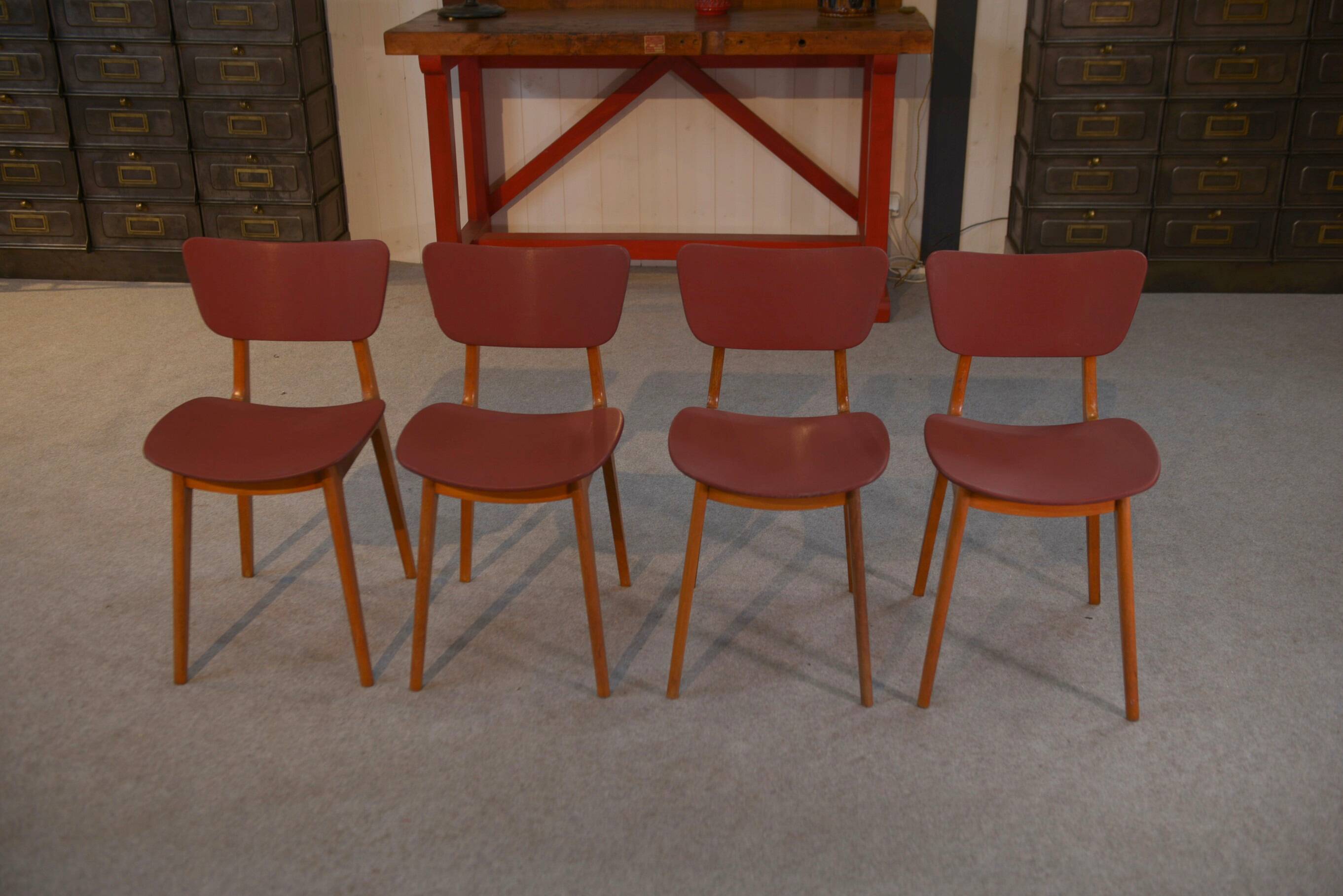 Set of 4 designer chairs in oak and red leatherette from the 1960s