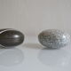 2 boxes in lithographed sheet metal in the shape of a pebble