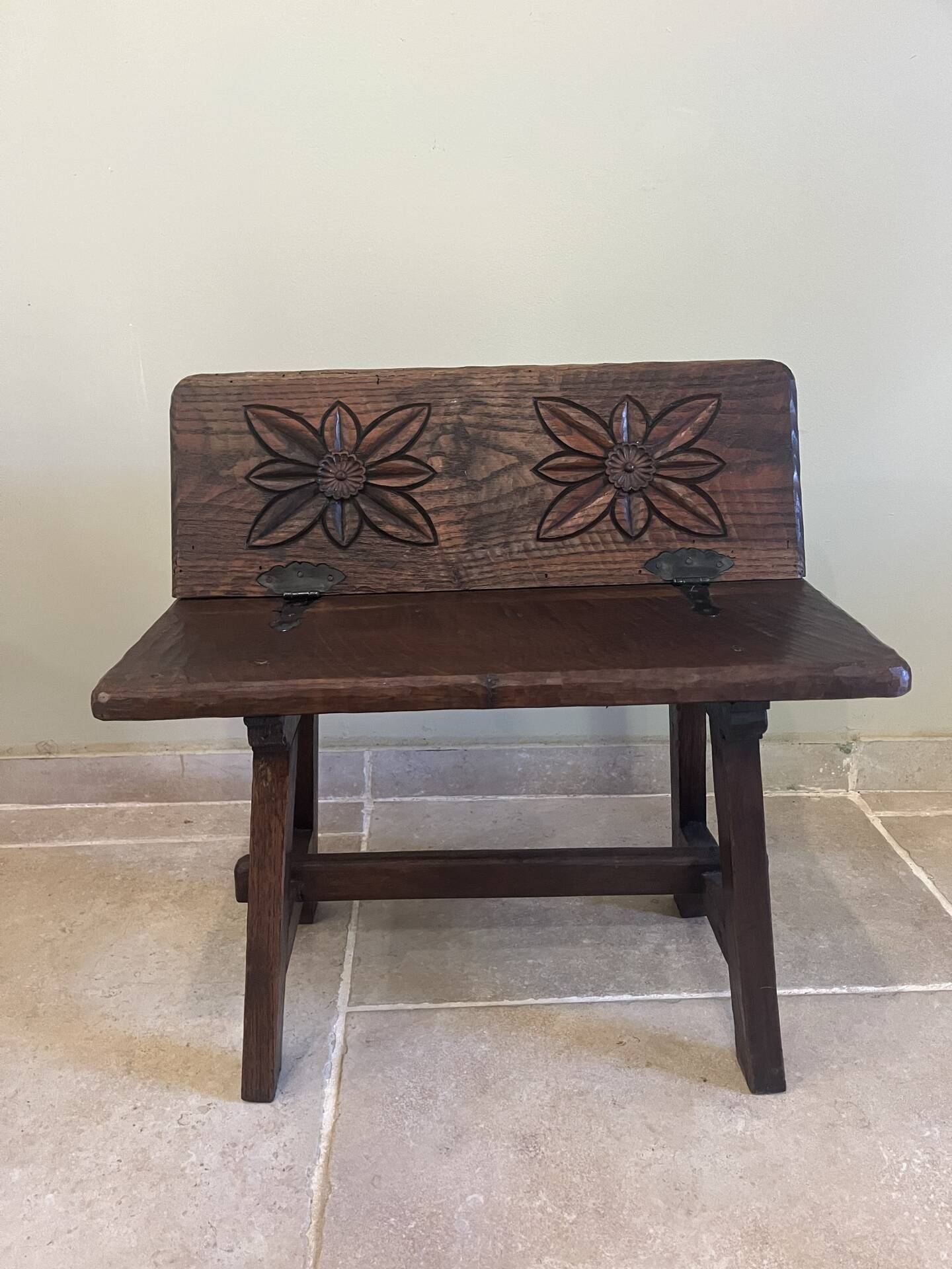 Small antique wooden bench with a folding backrest.
