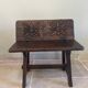 Small antique wooden bench with a folding backrest.