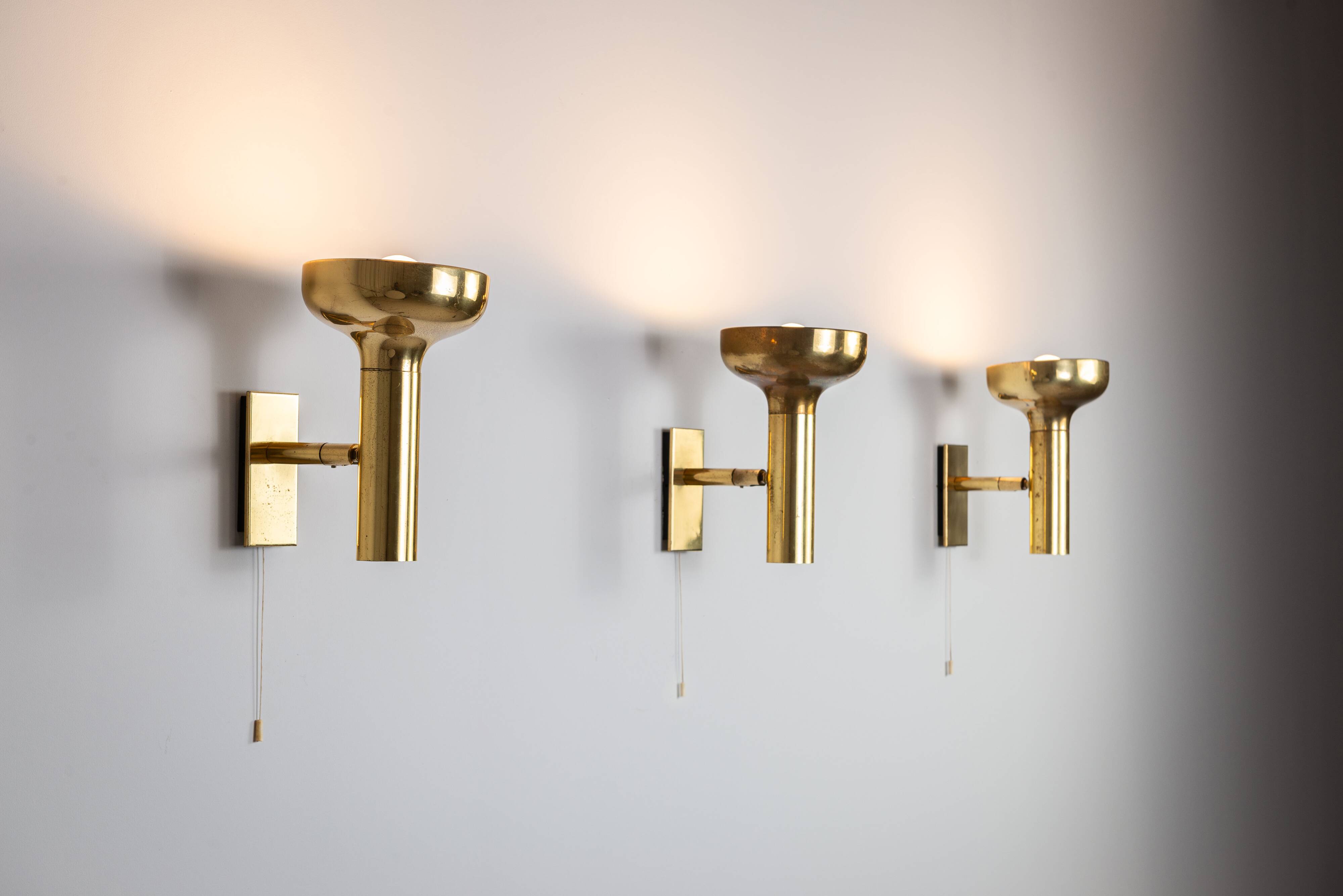 Set of three brass adjustable wall lamps