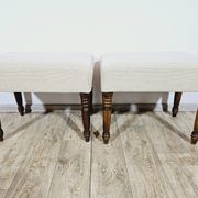 A pair of English upholstered pouffes/footstools from the 19th century