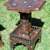 A folding chair and a carved Syrian table with 19th-century mother-of-pearl inlays.