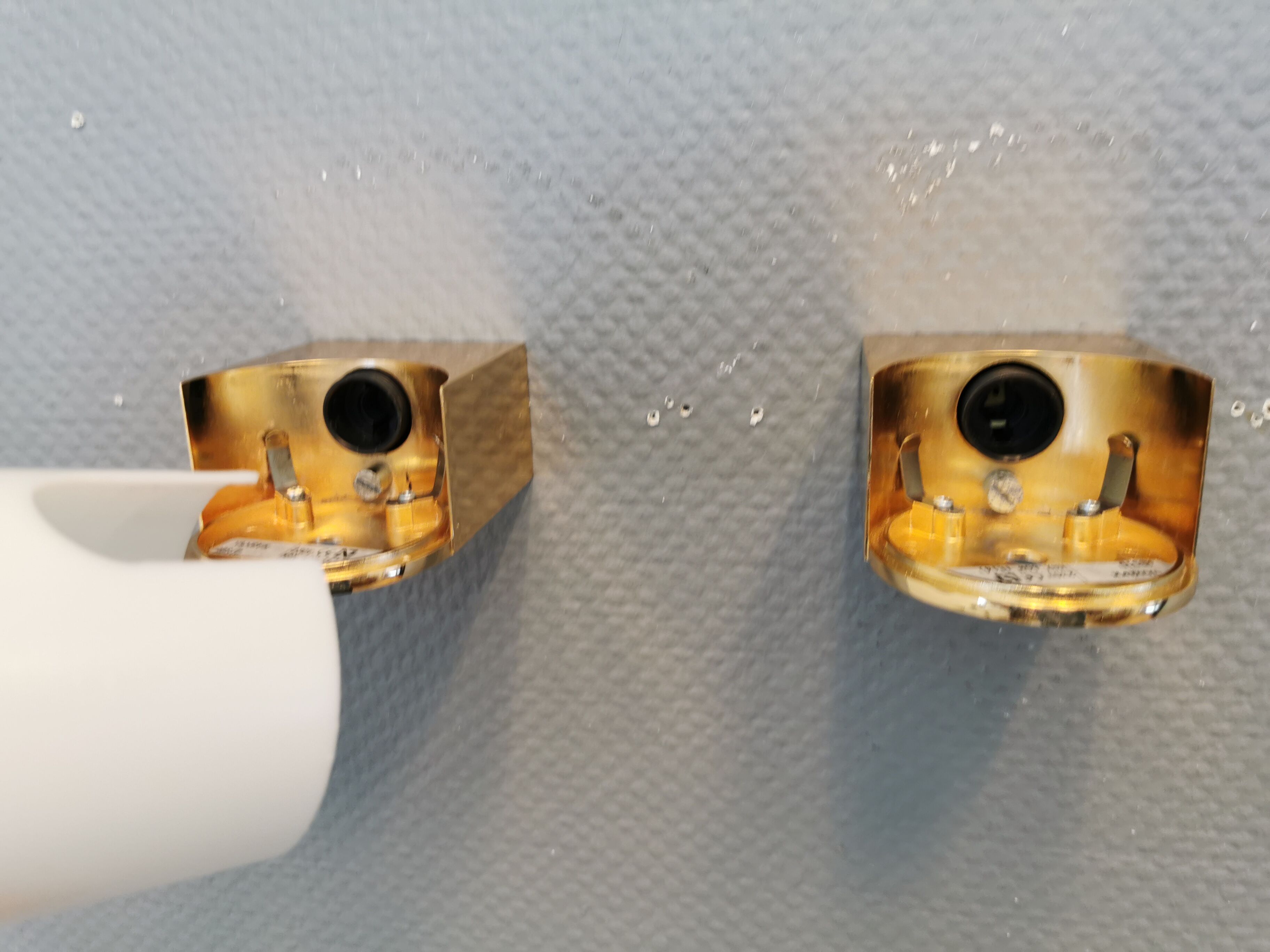 Wall lamps with milky white acrylic plastic shades and solid brass bases