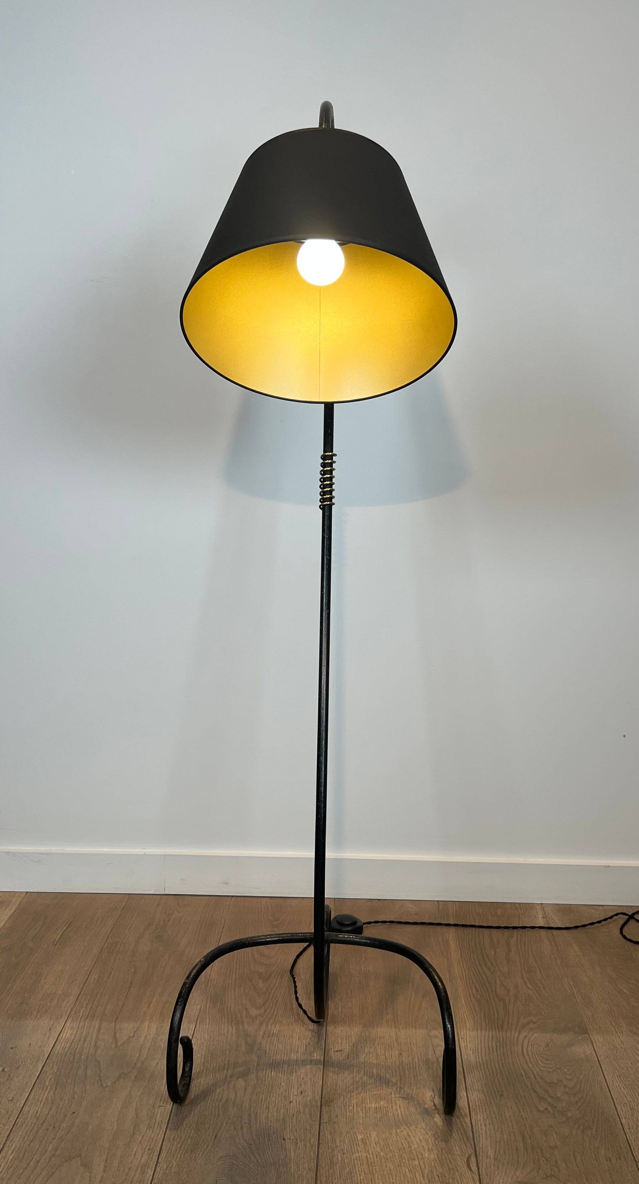 Design floor lamp in black lacquered metal and brass.
