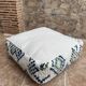 Berber floor pouf: Handwoven Moroccan wool cushion.
