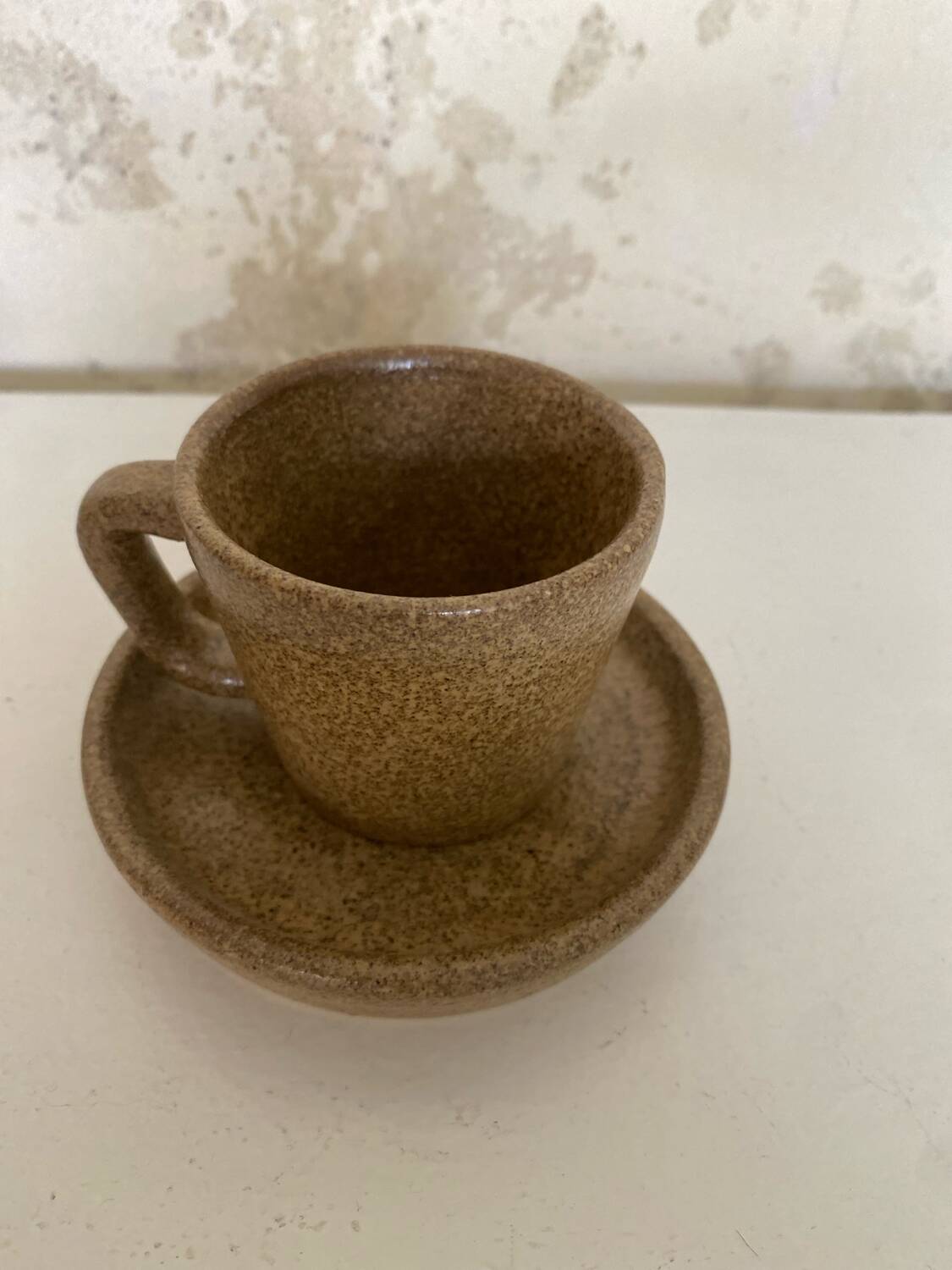 Set of stoneware coffee cups with saucers
