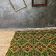 Green and yellow handmade rug with delicate colourful flowers