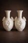 Pair of biscuit vases decorated with putti and ram's head.