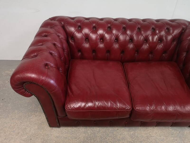 Red two-seater chesterfield sofa
