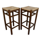 pair of bar stools, made of wood with a straw seat
