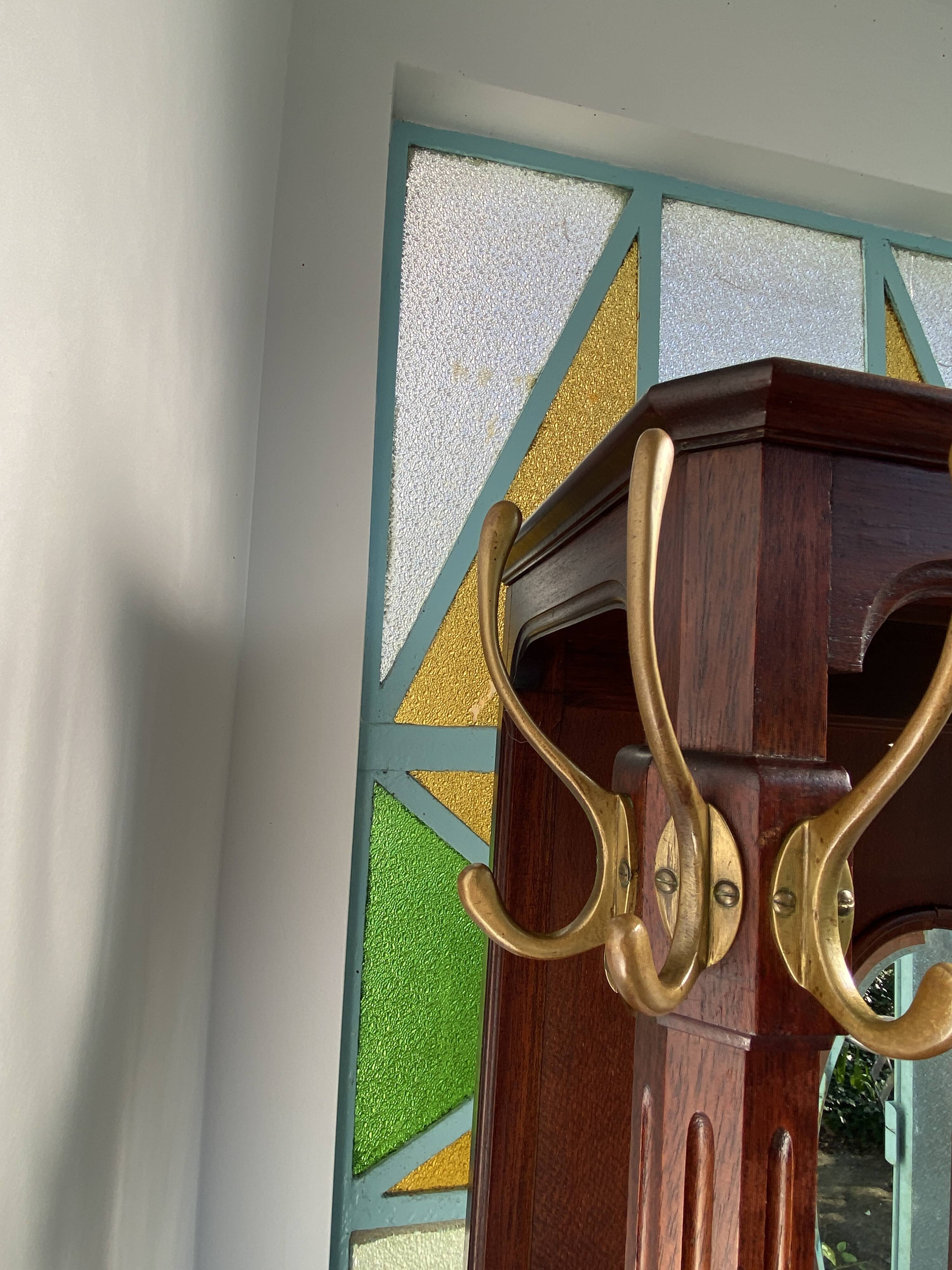 Antique wooden coat rack with mirror and shelf.