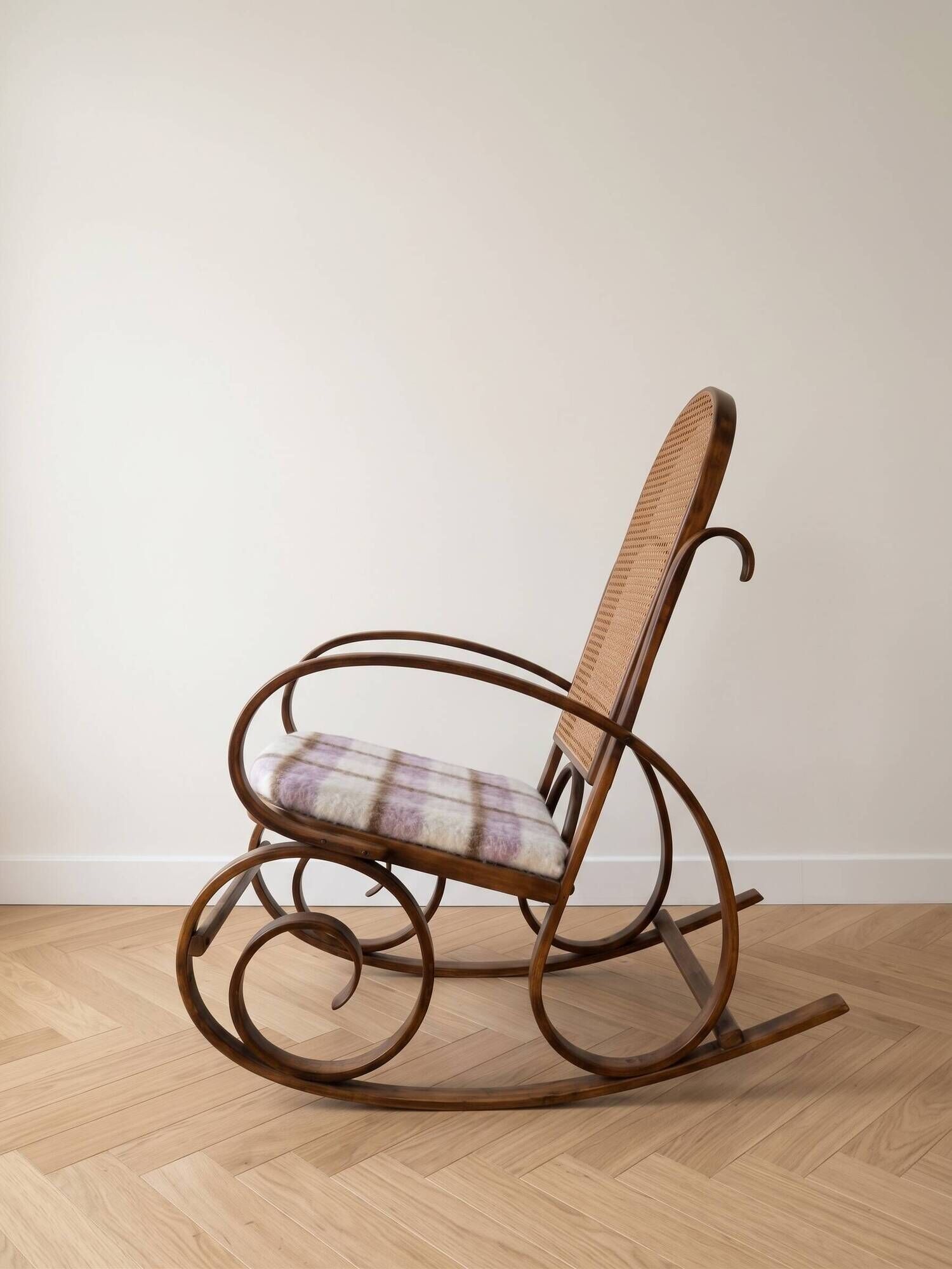 Antique rocking chair in curved wood and caning.