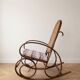 Antique rocking chair in curved wood and caning.