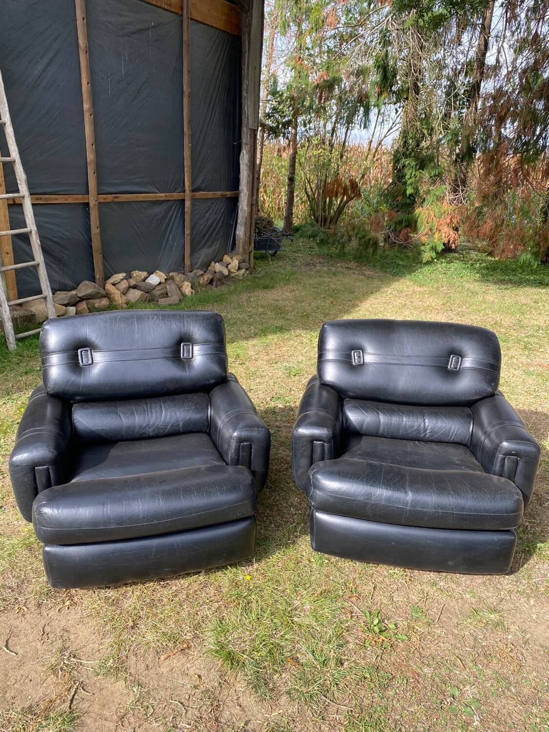 Pair of black imitation leather armchairs