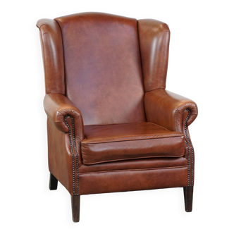 Fauteuil à oreilles en cuir de vache de couleur cognac