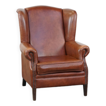 Fauteuil à oreilles en cuir de vache de couleur cognac