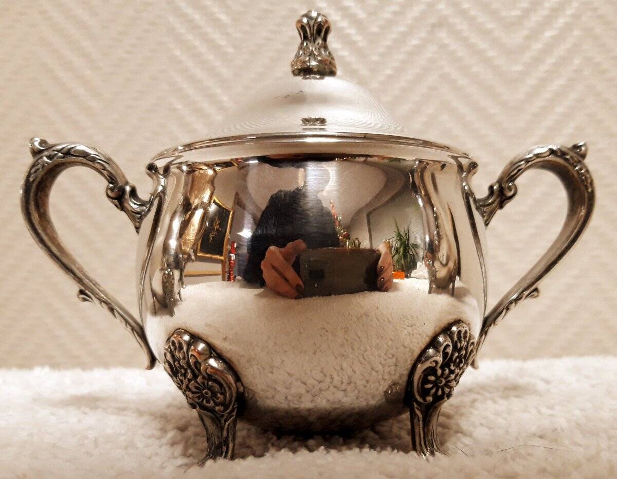 Silver-plated coffee and tea service including a coffee pot, a teapot, and a sugar bowl.