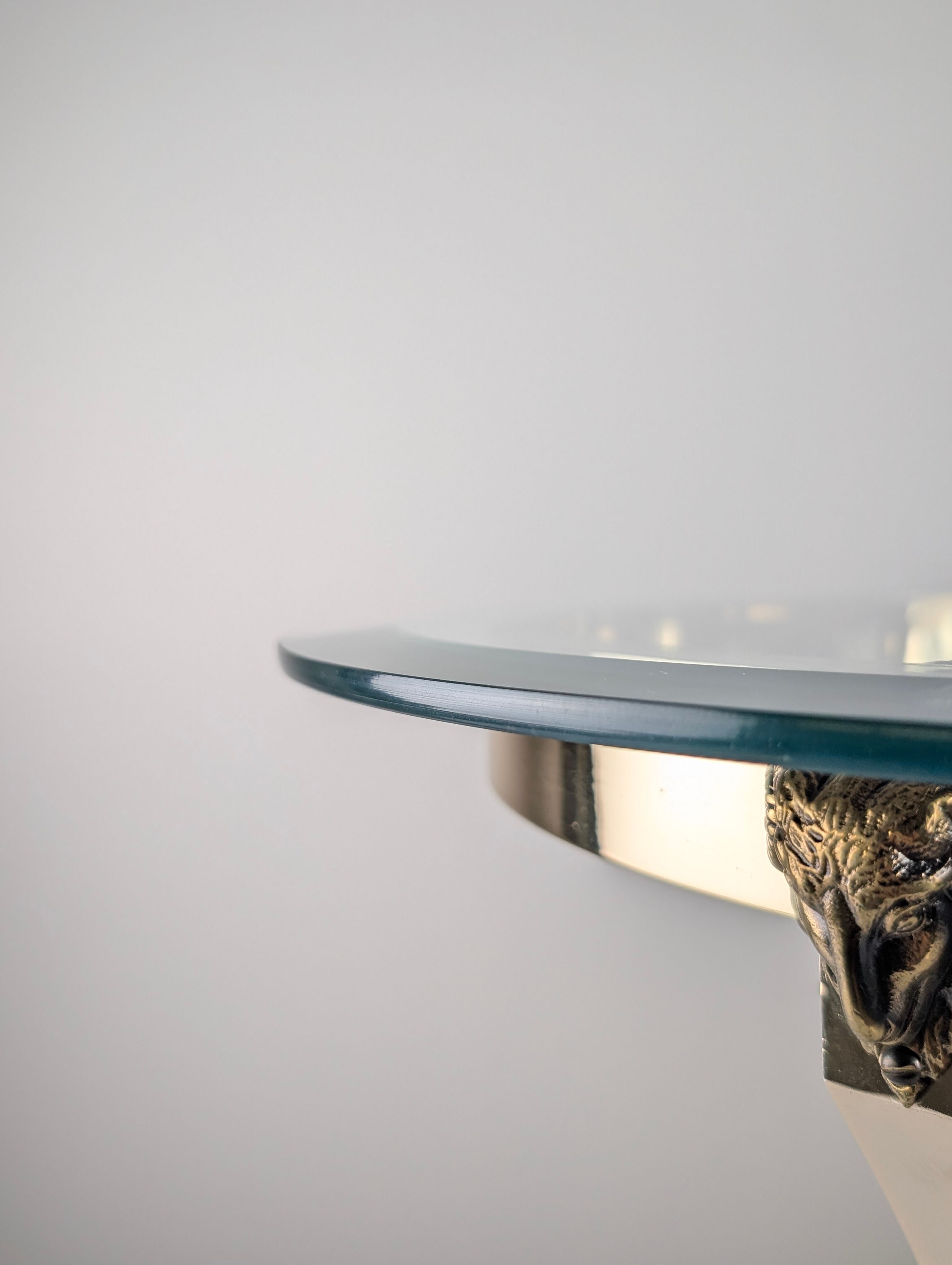 Neoclassical side table in brass and bevelled glass with ram's heads, 1970s.