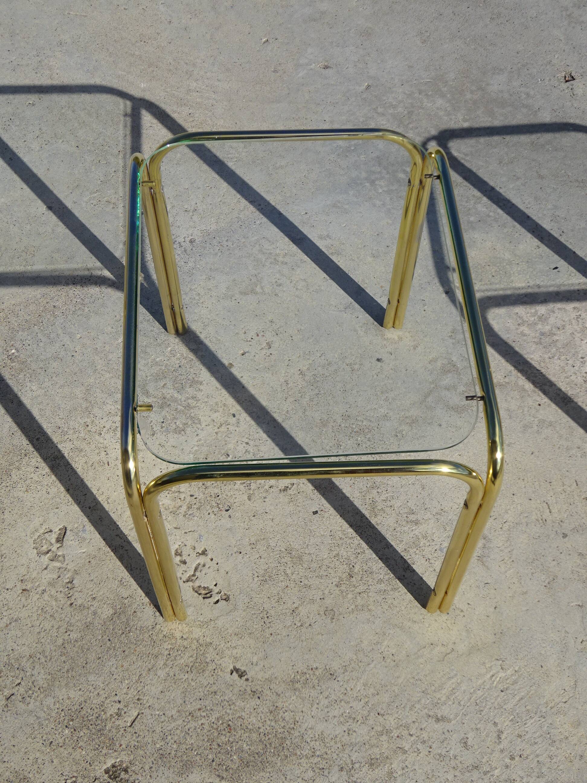 Nested tubular tables in gold metal.
