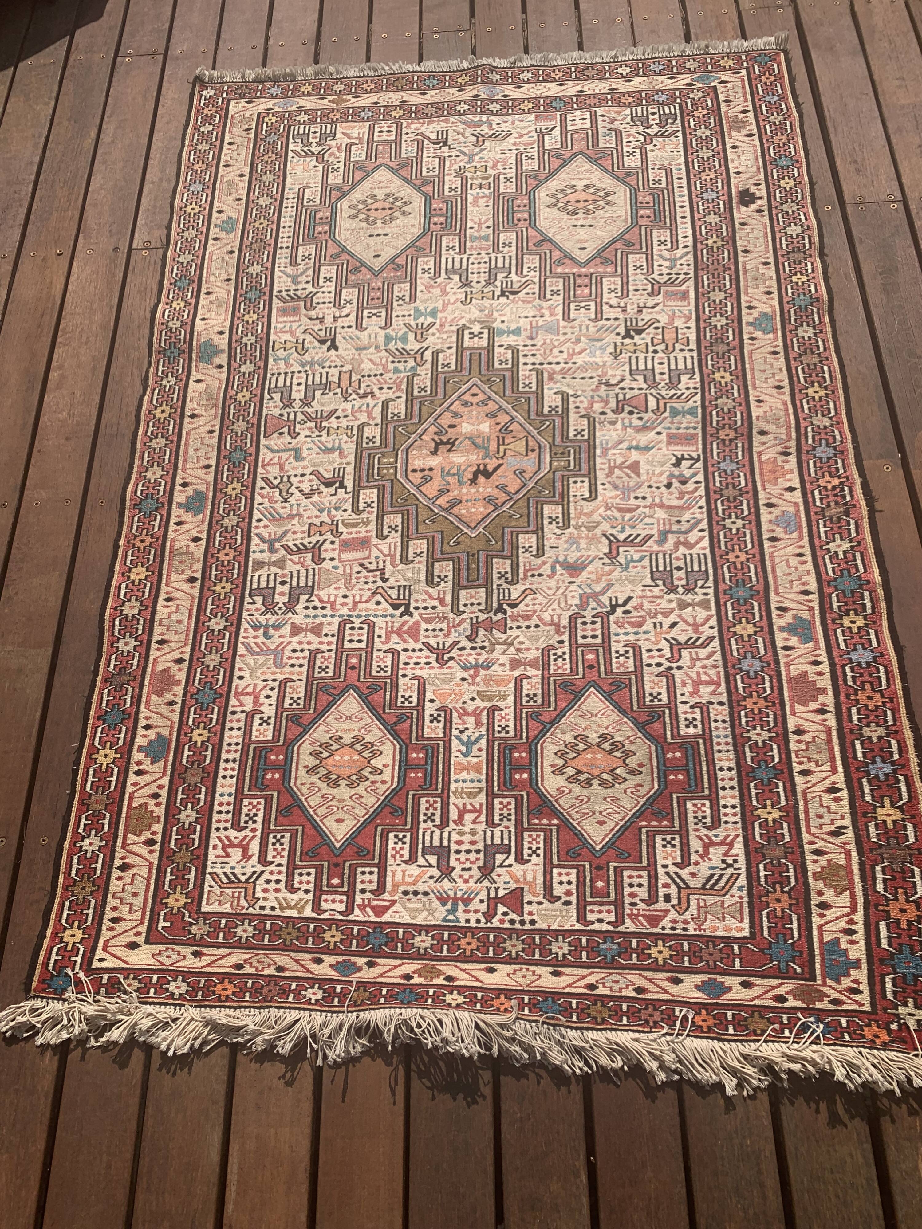 Hand-knotted silk carpet purchased in Iran – geometric and animal design –