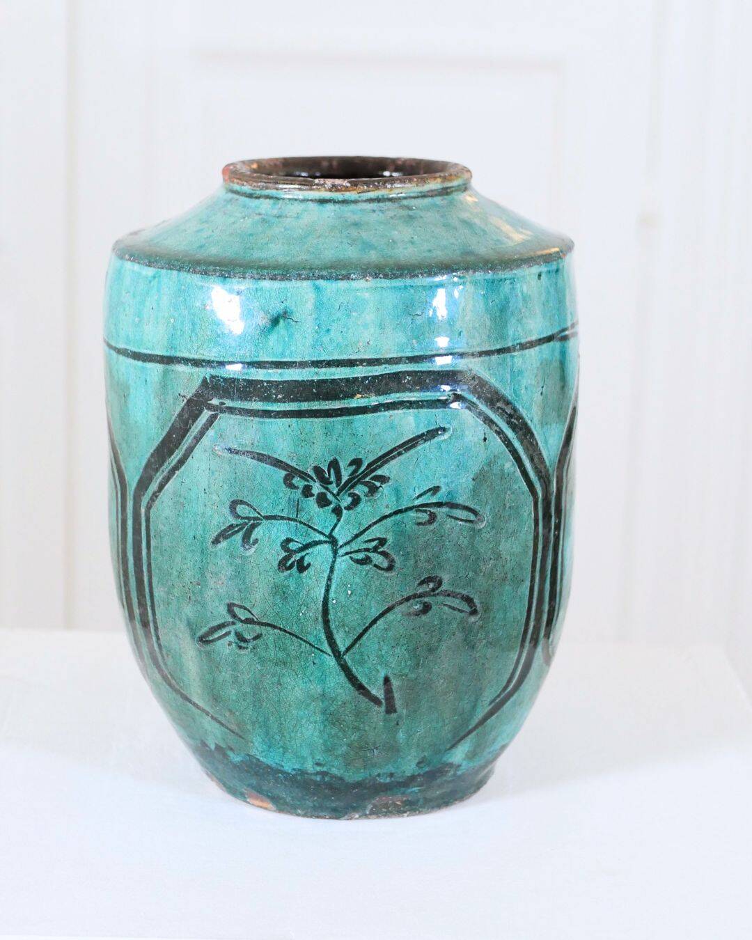 Chinese glazed earthenware vase with bird and flower decoration on a green background
