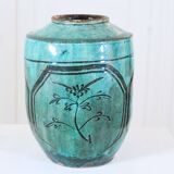 Chinese glazed earthenware vase with bird and flower decoration on a green background