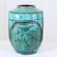 Chinese glazed earthenware vase with bird and flower decoration on a green background
