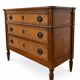 Light walnut commode in Louis XVI style with fluted motifs and three drawers.