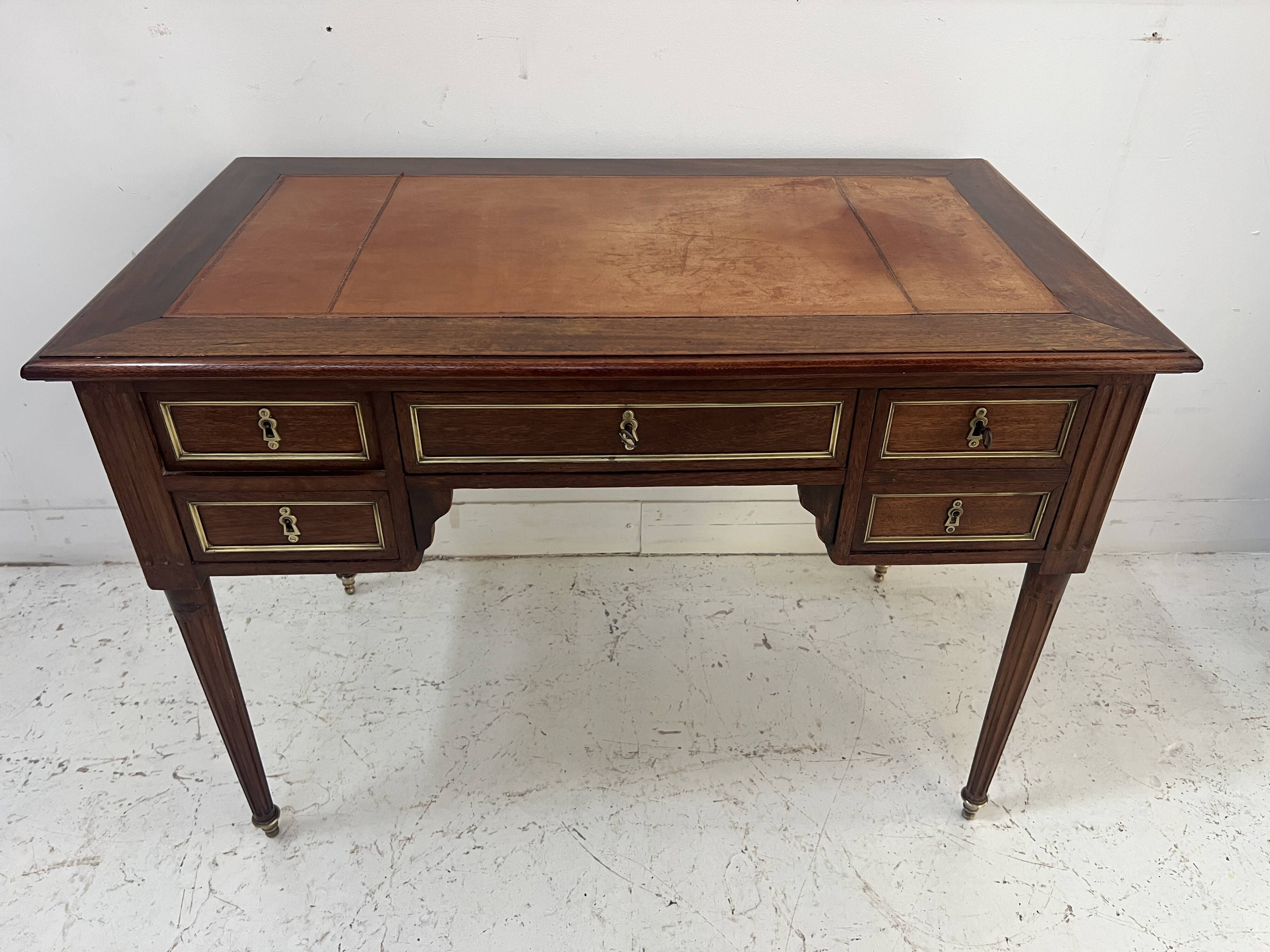 Louis XVI style desk in mahogany and mahogany veneer, 20th century.