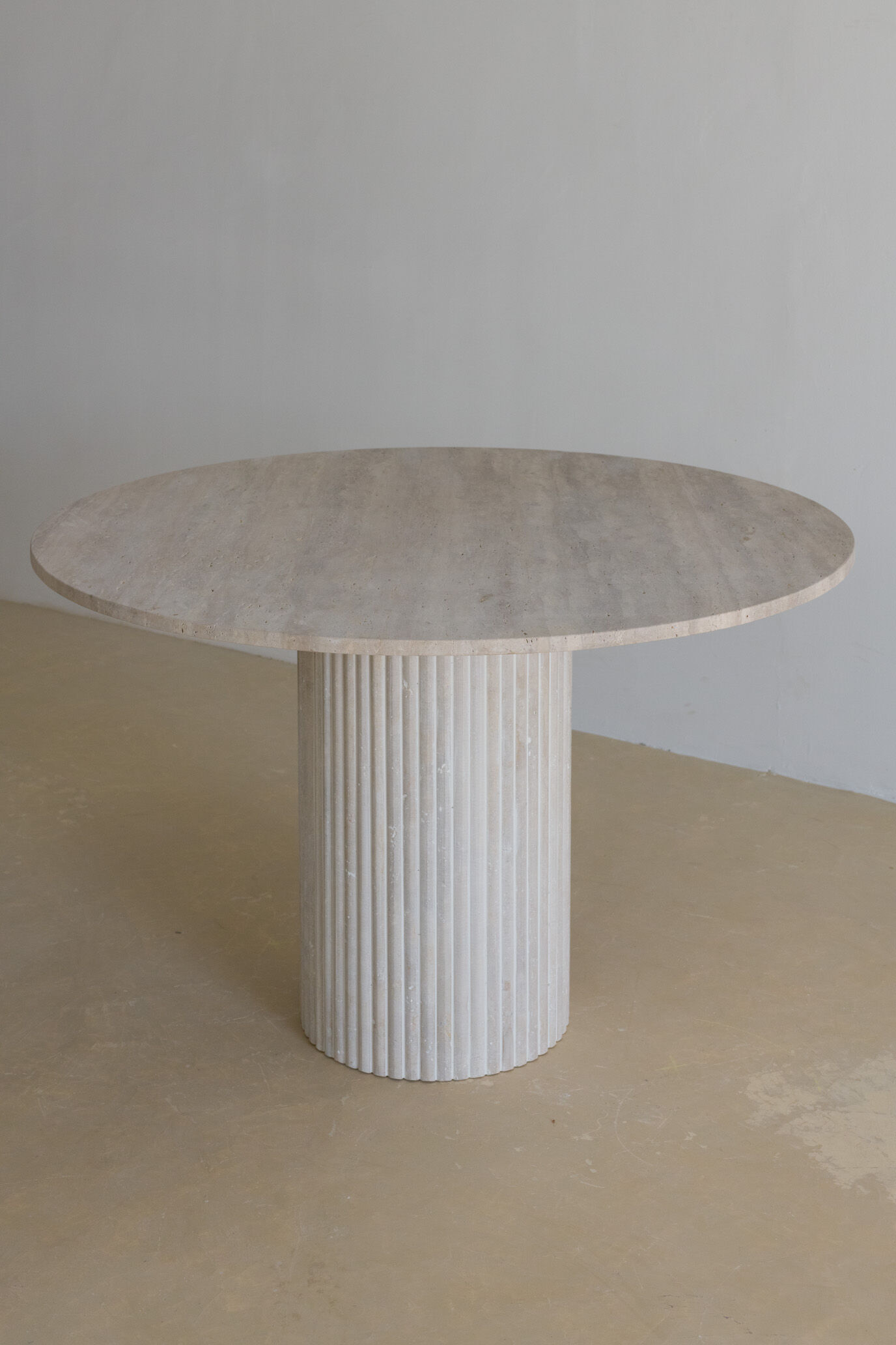 Omega circular dining table in natural travertine