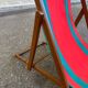 Vintage folding wooden deck chair with red and green striped canvas from the 1970s.