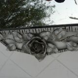 Beveled mirror with art-deco wrought iron frame and floral decor with hanging chain