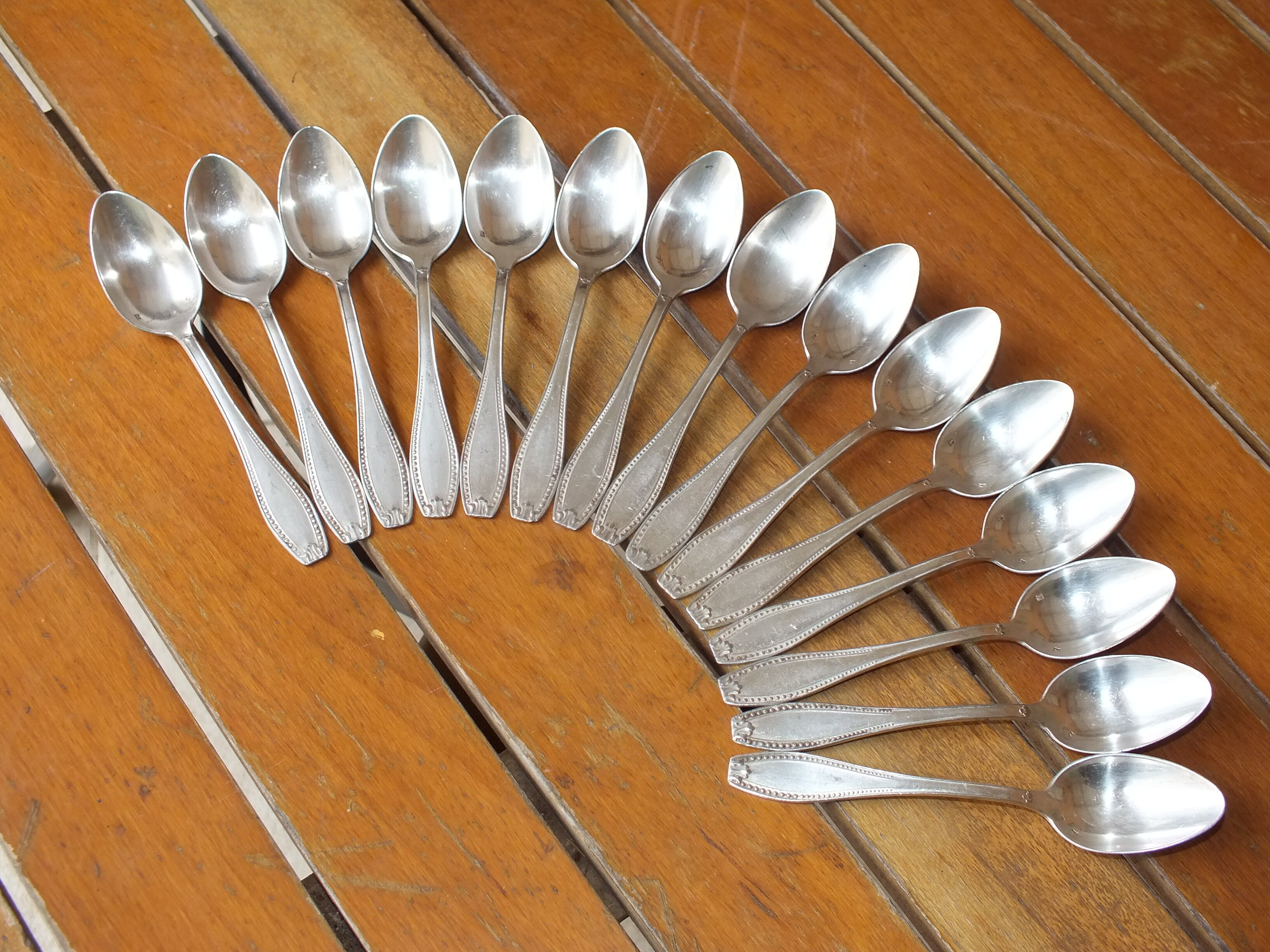 15 small silver metal spoons with rows of beads