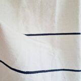 Handwoven throw with black stripes and pom-poms