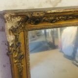Old mirror with gilded leaves and flowers carved on top of it 1800s