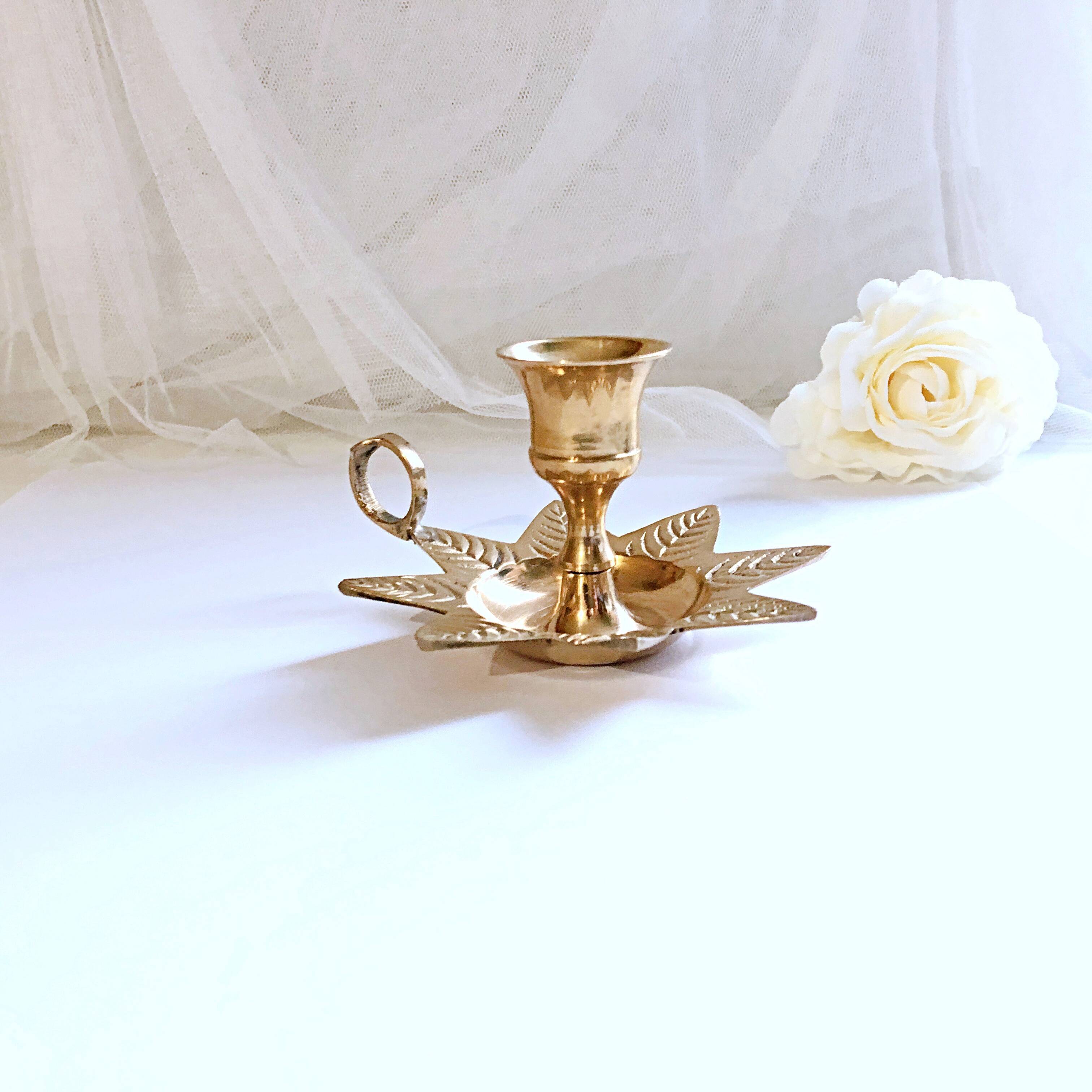 Golden brass hand candle holder decorated with leaves