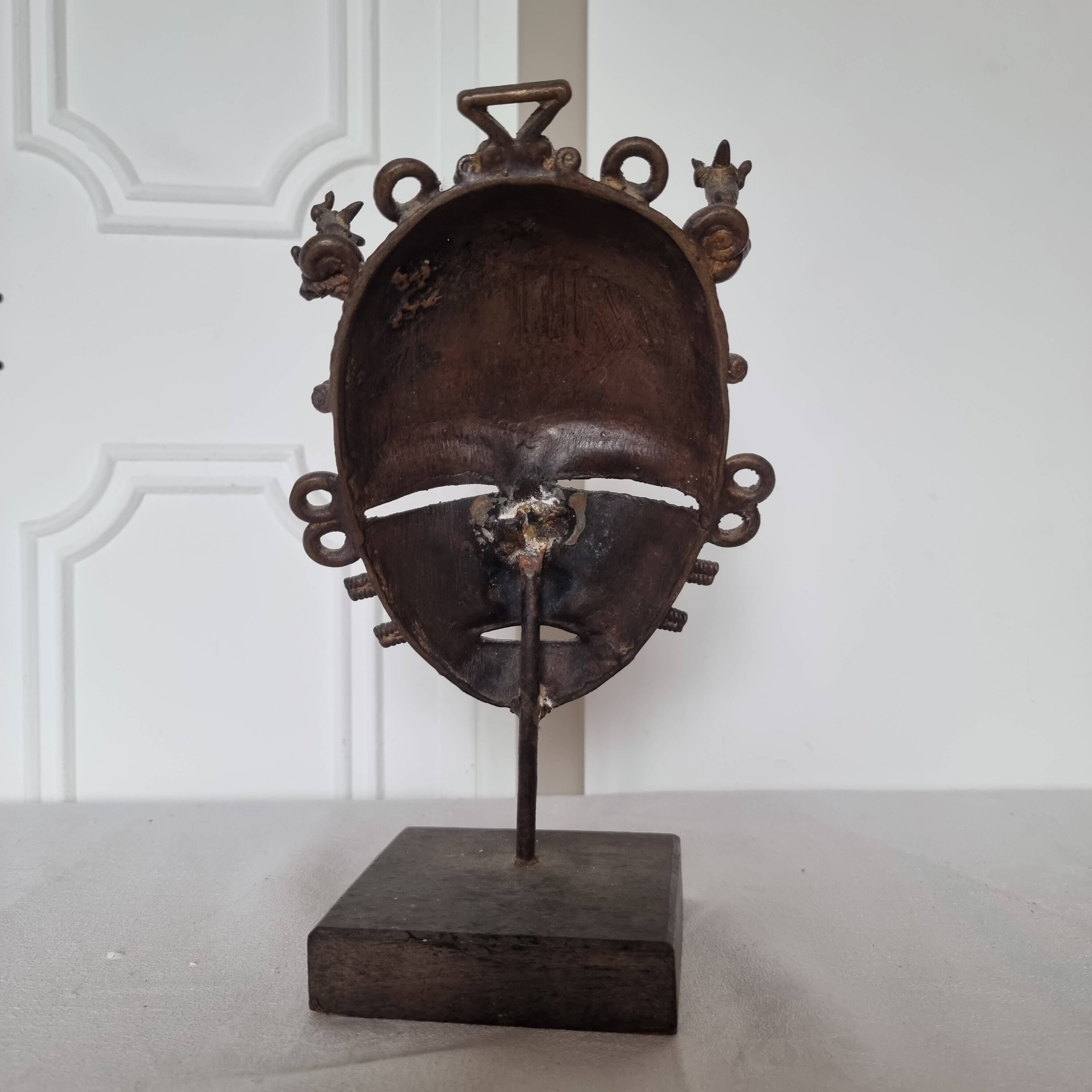African bronze mask on pedestal, from Ivory Coast, dating
