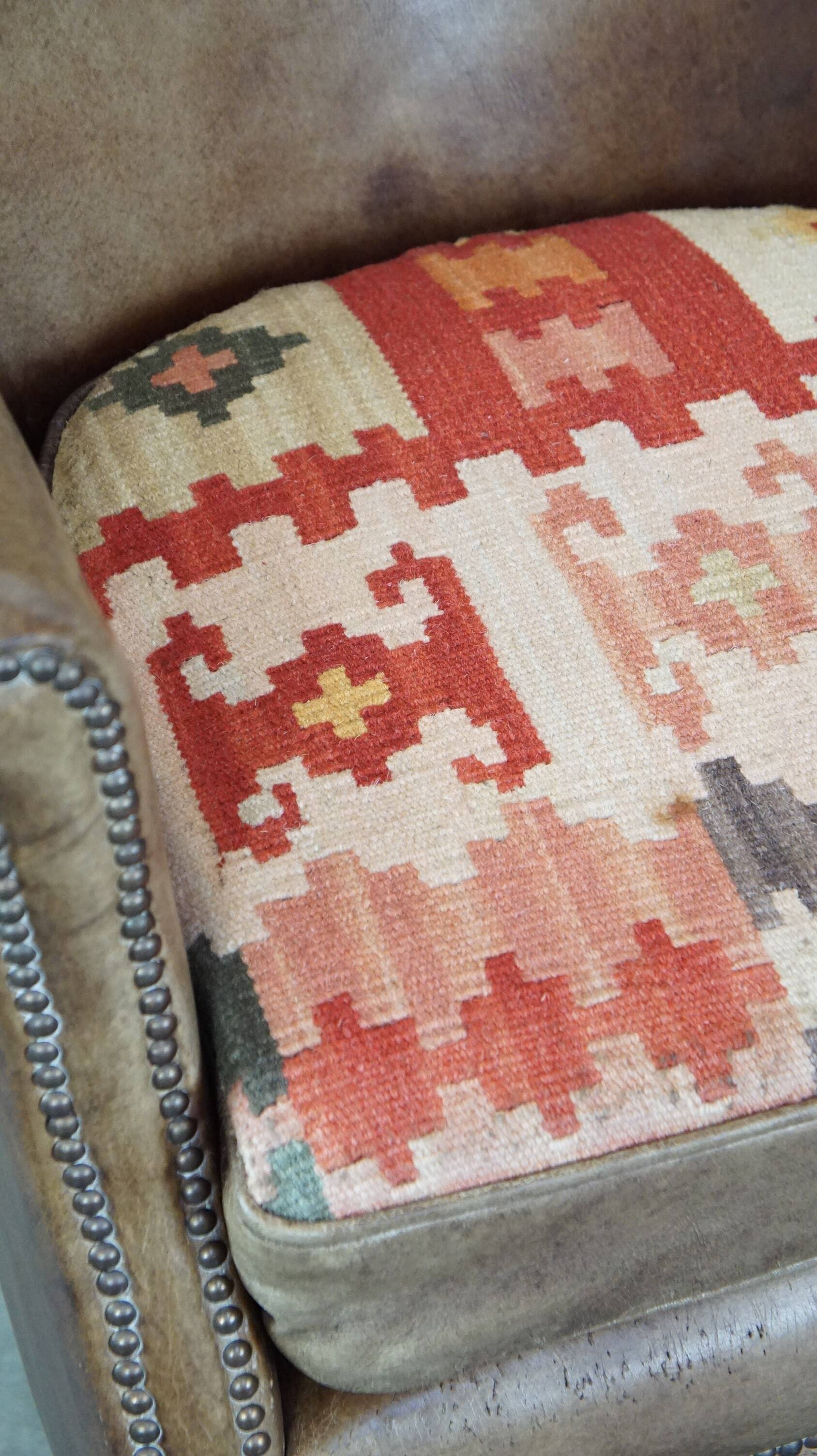 Subtle leather armchair with a reversible kilim seat cushion