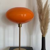 Table lamp with a vintage orange glass globe saucer and a gold base
