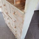 Craft cabinet with drawers with a very old tobacco advertisement in the background